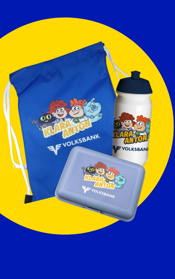 Blauer Turnbeutel, Trinkflasche und Brotdose mit „Klara & Anton“-Motiv der Volksbank auf blauem Hintergrund mit gelbem Kreis.